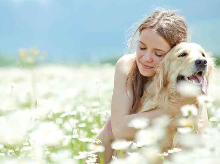 Die junge Frau genießt die Umarmung, der Hund jedoch nicht – Shutterstock / Nina Buday